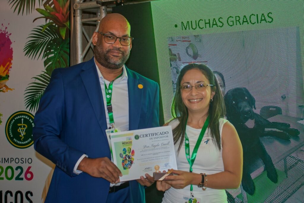 El Dr. Andrés Bailey entrega un reconocimiento a la Dra. Tayda Mariel O'Neill Ortega durante el Simposio de Medicina Veterinaria APMV 2026.
